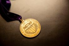 University of Washington medal on a purple ribbon with a solid grey background