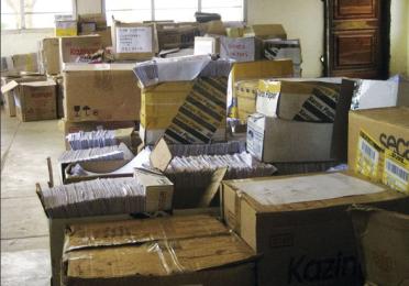 Piles of unorganized boxes and files in a room.