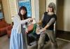 Liz and Sasha stand smiling holding the traditional GWSS Ph.D. sash with multiple years etched