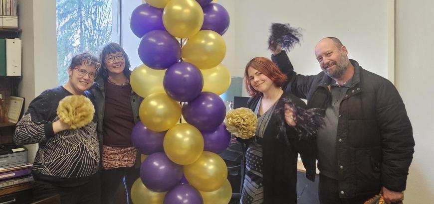 Group of 4 standing around balloon tower
