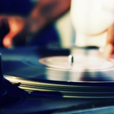Close-up of hands manipulating a vinyl record on a turntable.