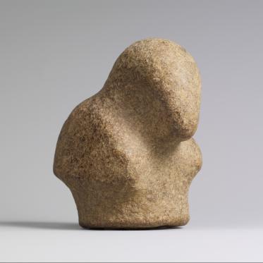 Abstract stone sculpture resembling a human torso with rounded shoulders and no facial features, shown against a light gray background.